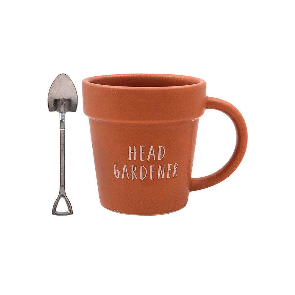 Brown plant pot styled mug with a spade styled spoon on a white background