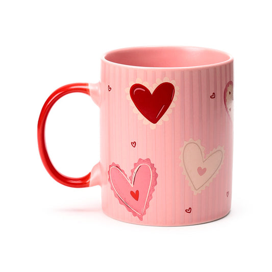 Pink mug with red heart designs on a white background