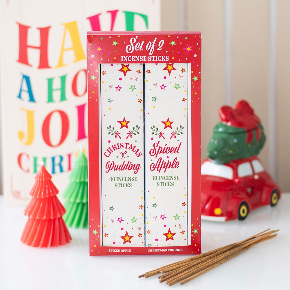 Set of 2 incense sticks packaging with Christmas pudding and spiced apple scents on a white surface.