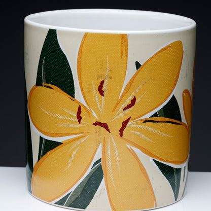 Ceramic mug with a large yellow flower design on a white background