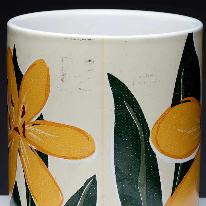 Ceramic mug with yellow floral design on a white background