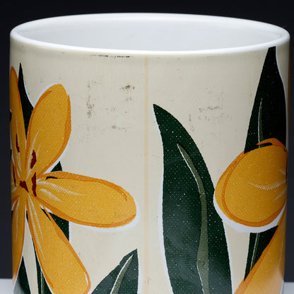 Ceramic mug with yellow floral design on a white background