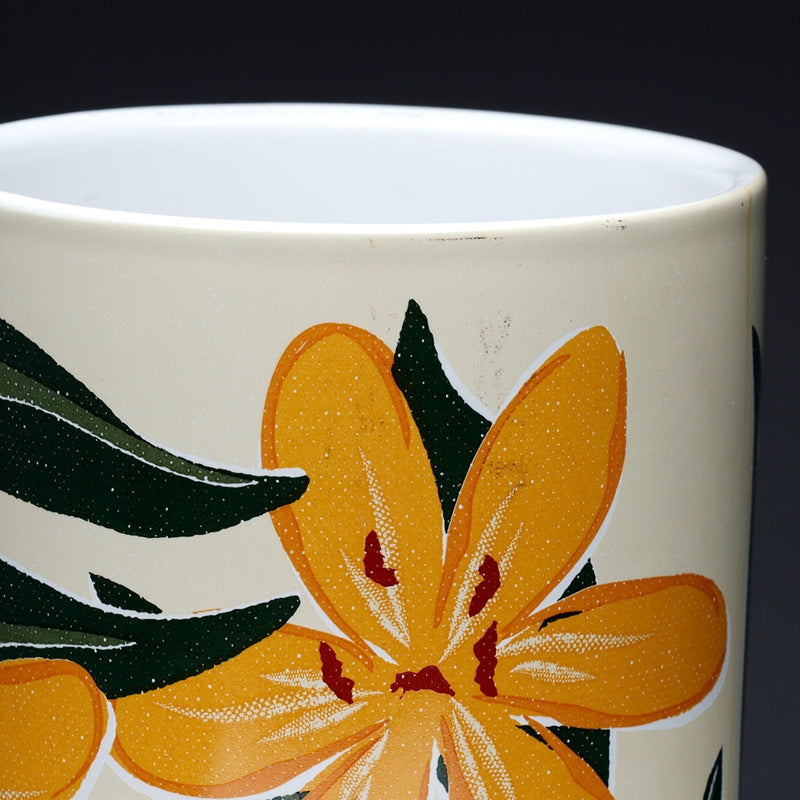 Ceramic mug with orange floral design on a white background