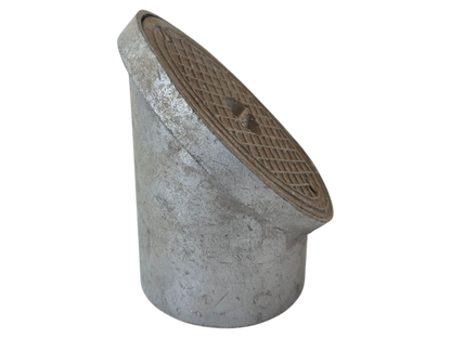 A galvanized steel drainage pipe fitting with a slanted access cover, featuring a textured cast iron-style top with a diamond grid pattern.