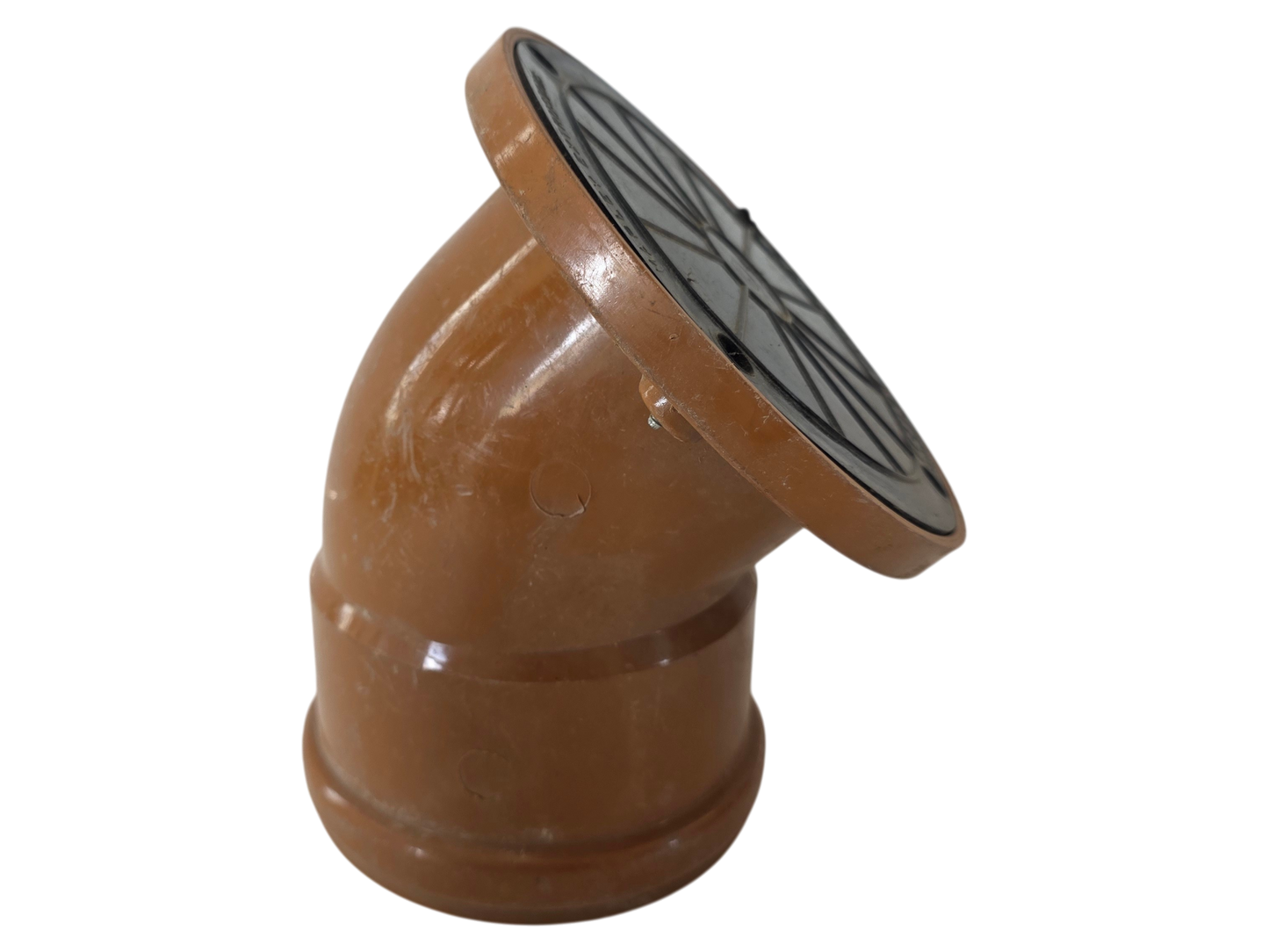 A terracotta clay downspout elbow fitting with a circular black metal grate cover on the top, isolated on a white background.