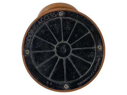 A circular black metal access plate with radial spokes and a brown outer frame, photographed on a plain white background.