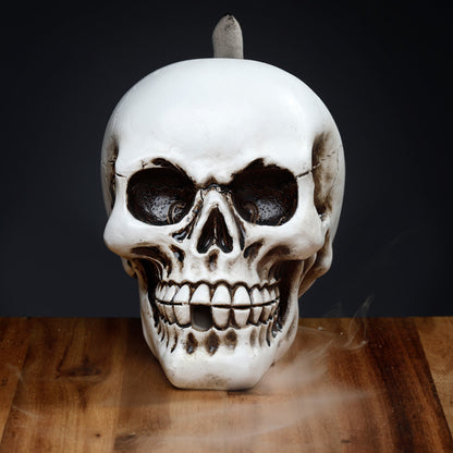 Skull-shaped candle on a wooden surface with a dark background