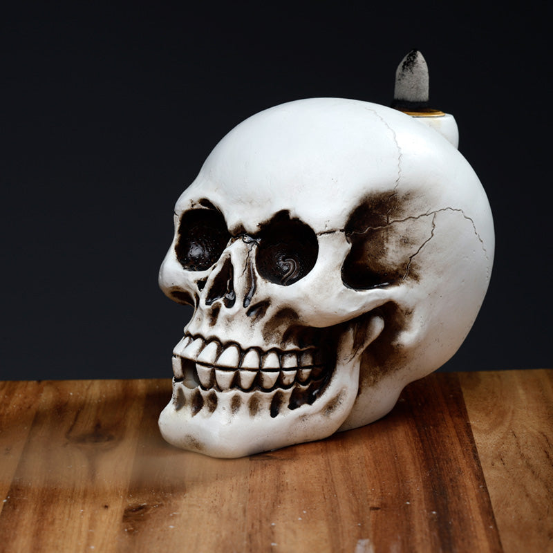 Skull-shaped object with a candle on a wooden surface