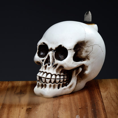 Skull-shaped object with a candle on a wooden surface