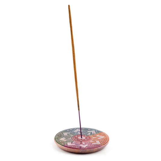 Incense stick on a colorful ceramic holder against a white background