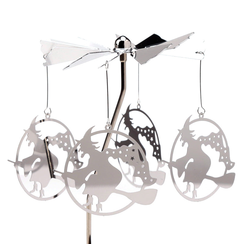 Decorative metal mobile with silhouettes of witches on broomsticks against a white background