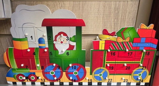 Wooden advent calendar shaped like a train with Santa Claus and presents.