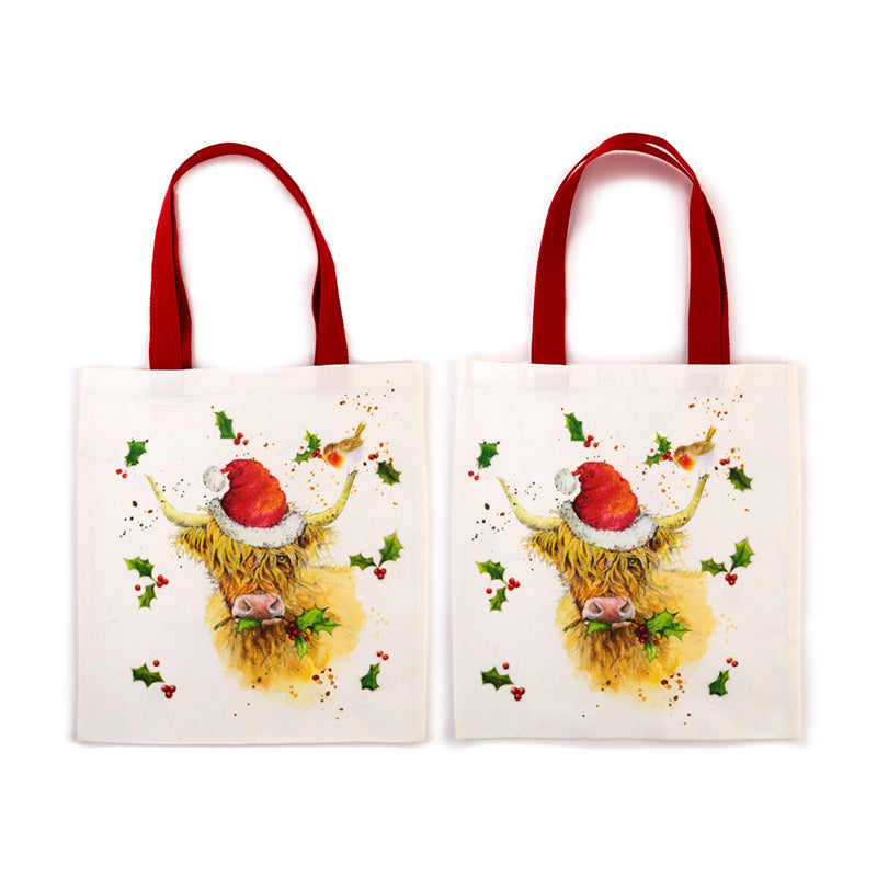 Two tote bags with a Christmas-themed design of a highland cow wearing a Santa hat on a white background.