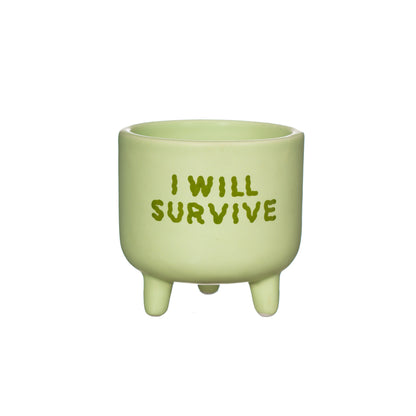 Green ceramic pot with 'I WILL SURVIVE' text on a white background
