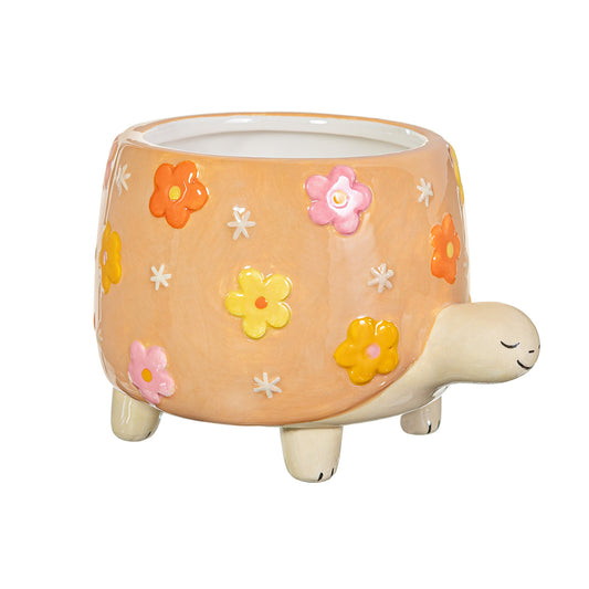 Ceramic turtle planter with floral designs on a white background
