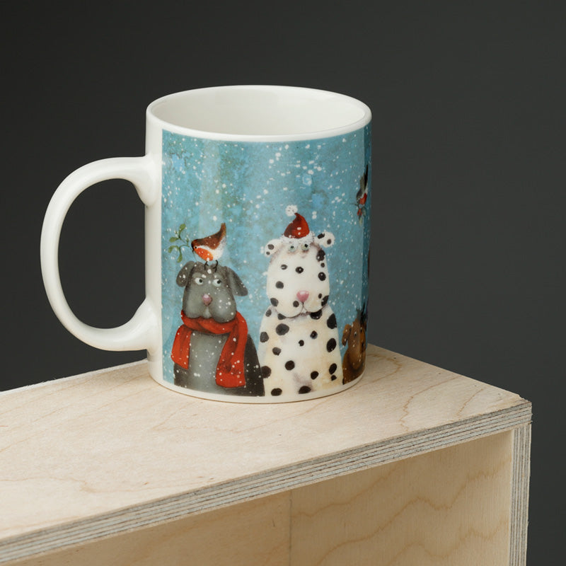 Mug with winter-themed design of dogs on a wooden surface
