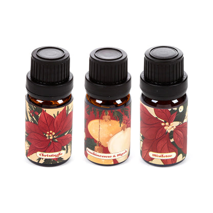 3 bottles of Christmas themed fragrance oils on a white background