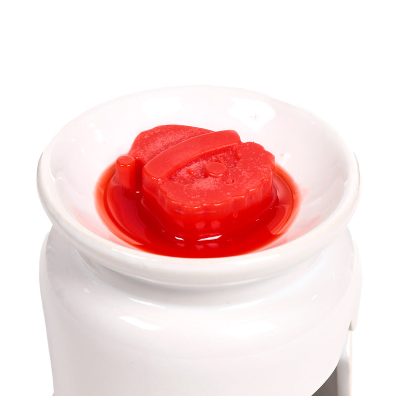 Christmas themed wax melt in a burner on a white background