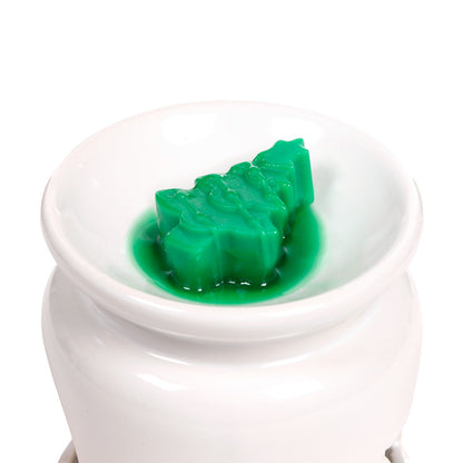 Christmas themed wax melt in a burner on a white background