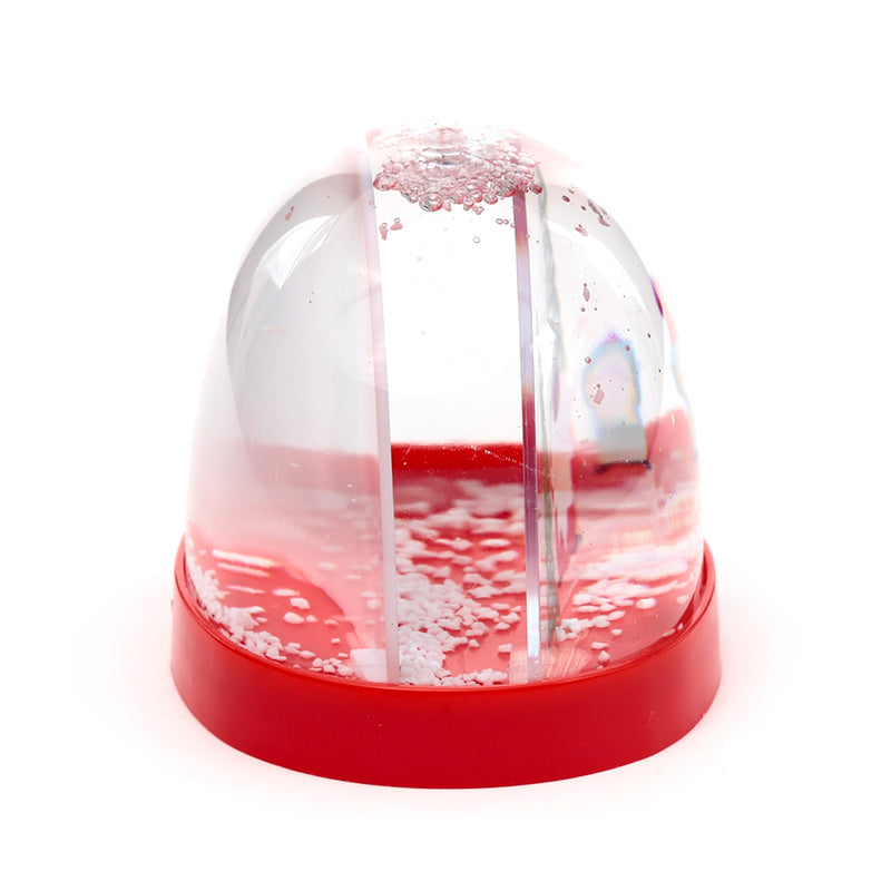Small snow globe with a red base on a white background