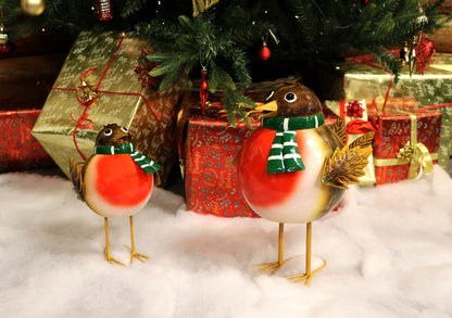 Decorative birds with scarves in front of a Christmas tree and presents