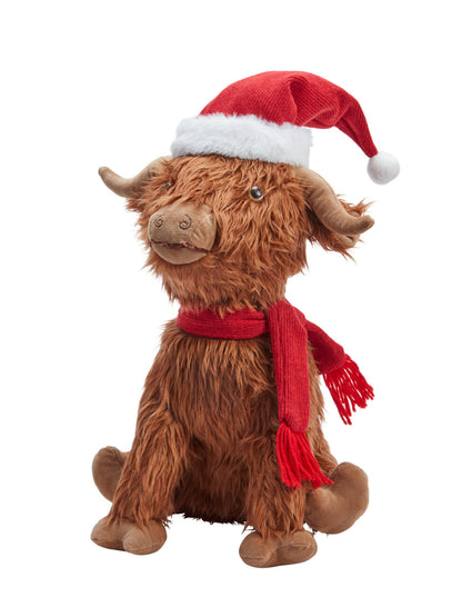 Plush toy Highland cow wearing a Santa hat and scarf on a white background