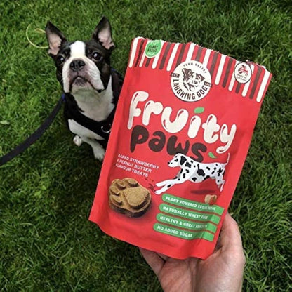 Laughing Dog Fruity Paws Dog Treats (Peanut Butter & Strawberry) 125g on grass next to a brown dog