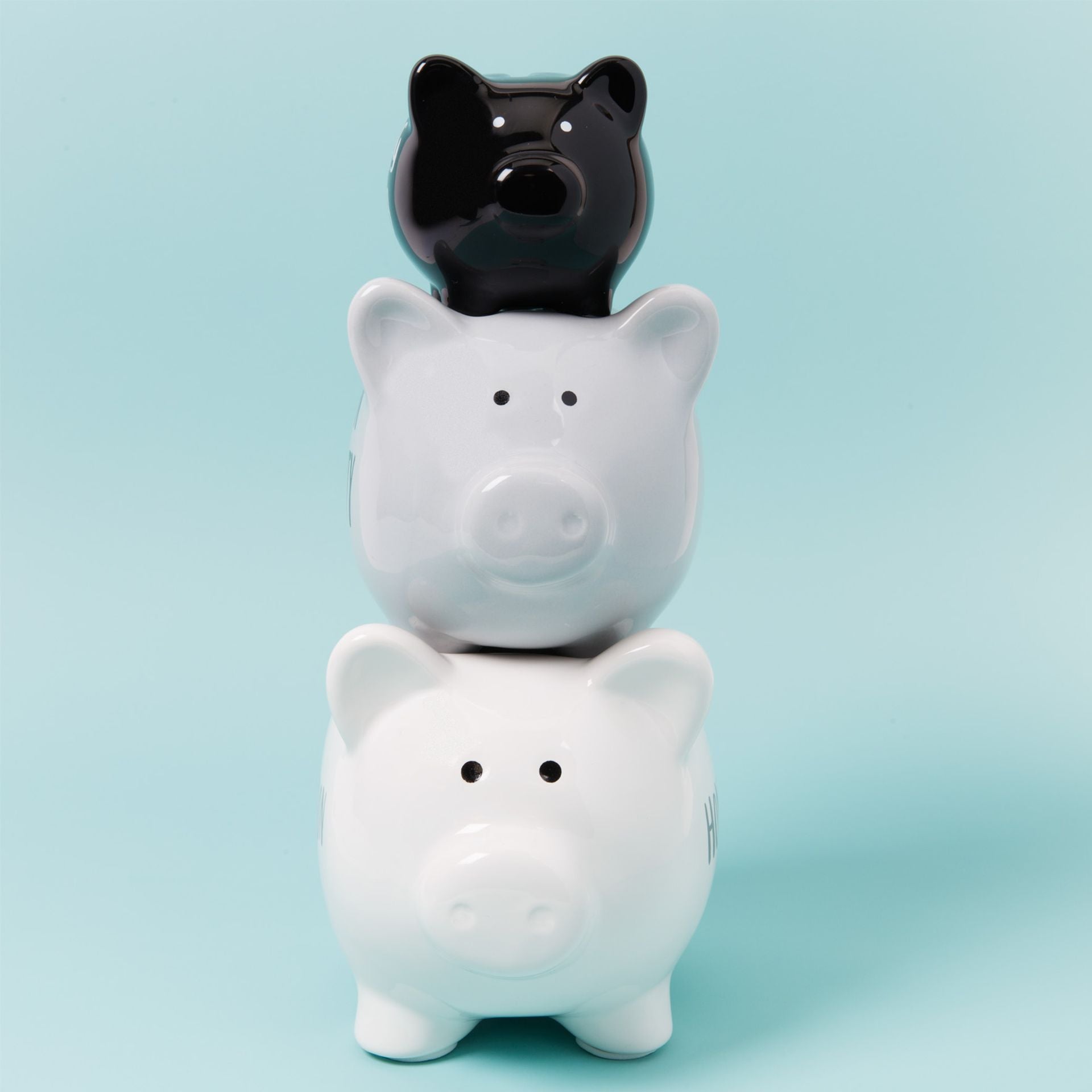 Three piggy banks stacked on top of each other with a light blue background