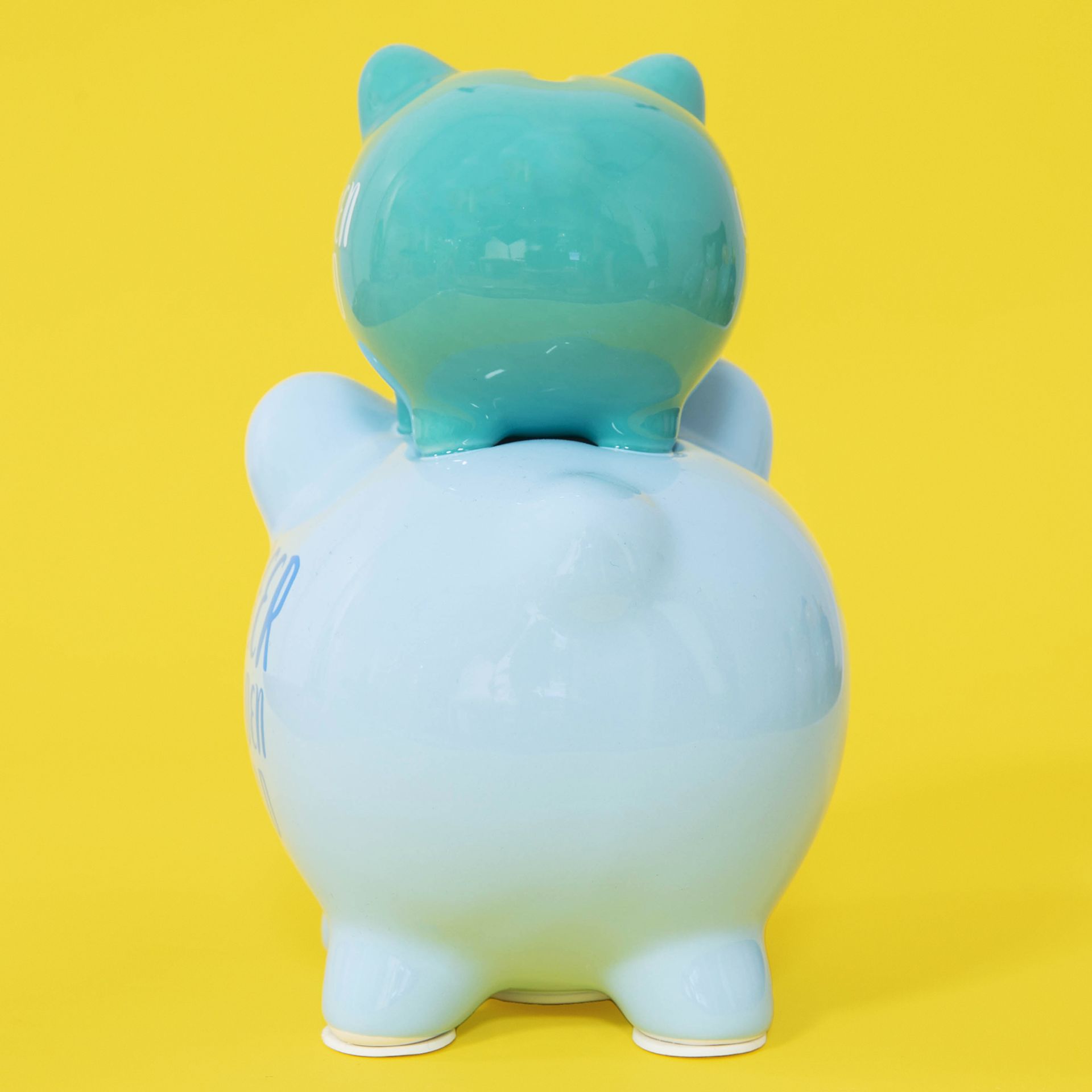 Gradient blue and green piggy bank with animal ears on a yellow background