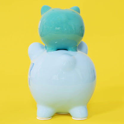 Gradient blue and green piggy bank with animal ears on a yellow background