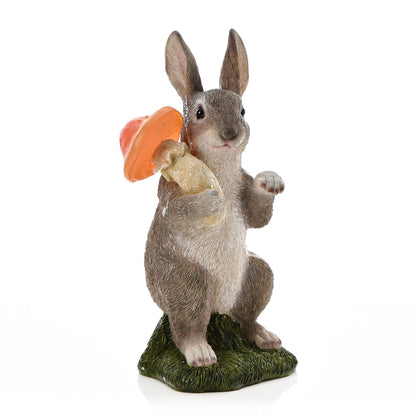 Statue of a rabbit holding a carrot on a white background