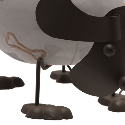 Close-up of a black and white ceramic dog figurine with a bone on a white background