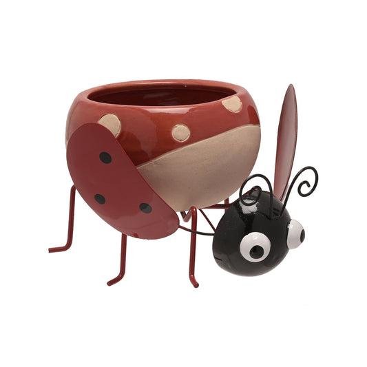 Ceramic ladybug planter with a small black ant figurine on a white background