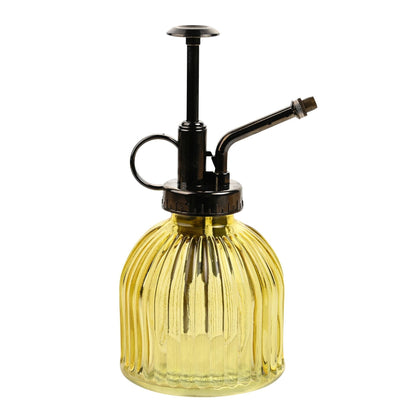 Yellow glass spray bottle with black metal nozzle on a white background