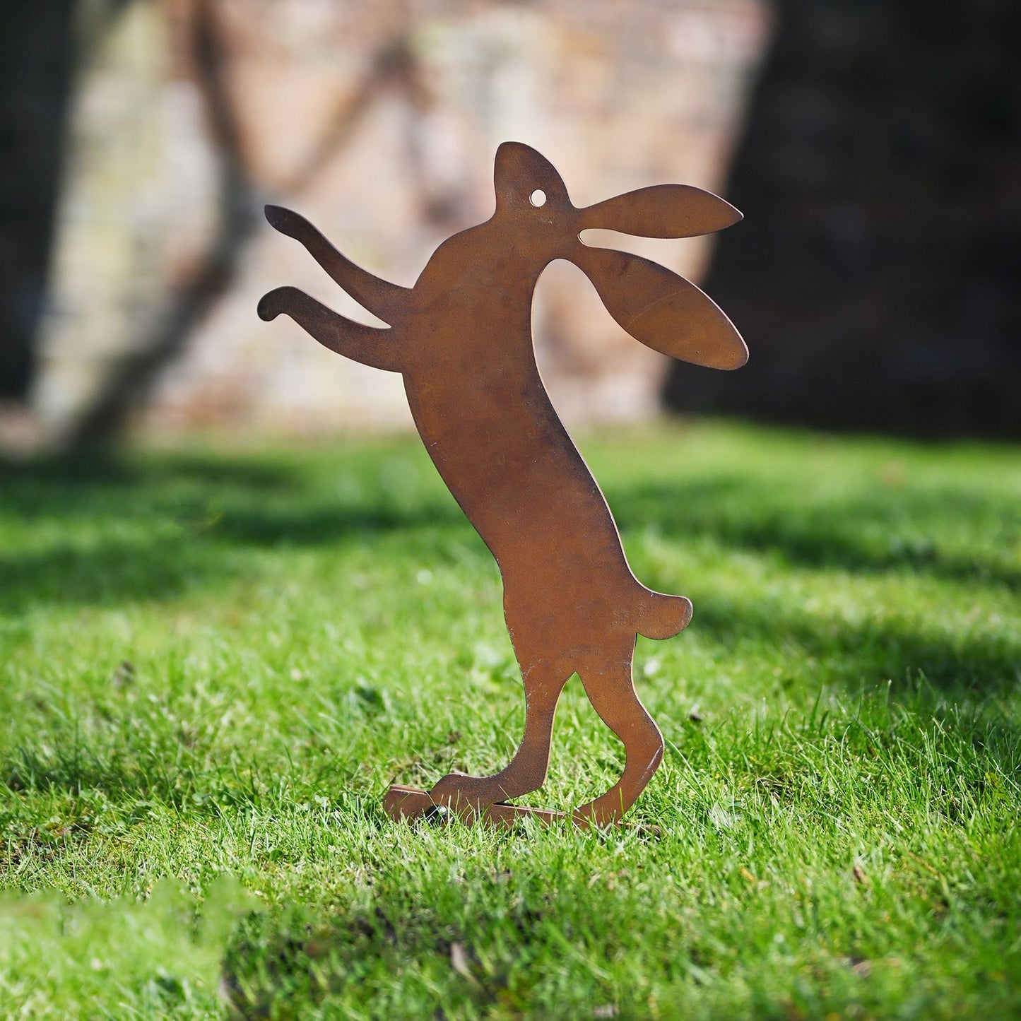 Metal dog sculpture on grass with blurred background