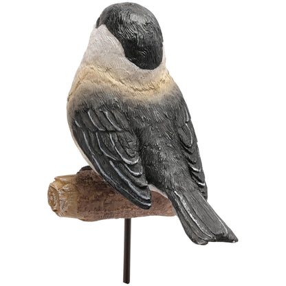Bird figurine perched on a branch against a white background