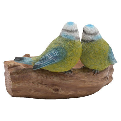 Decorative figurine of two birds perched on a log with a white background