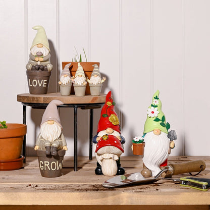 Decorative gnomes on a wooden surface with a white paneled wall in the background.