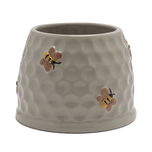 Ceramic planter with honeycomb design and bee decorations on a white background