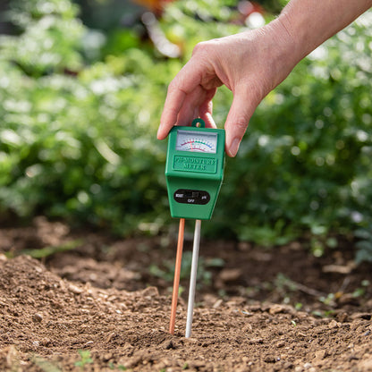 Person using a soil moisture meter in a garden setting