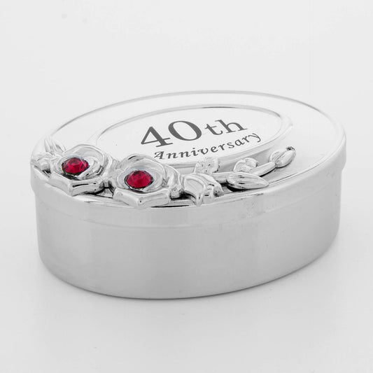 Silver ring box with '40th Anniversary' engraving and red gemstones on a white background