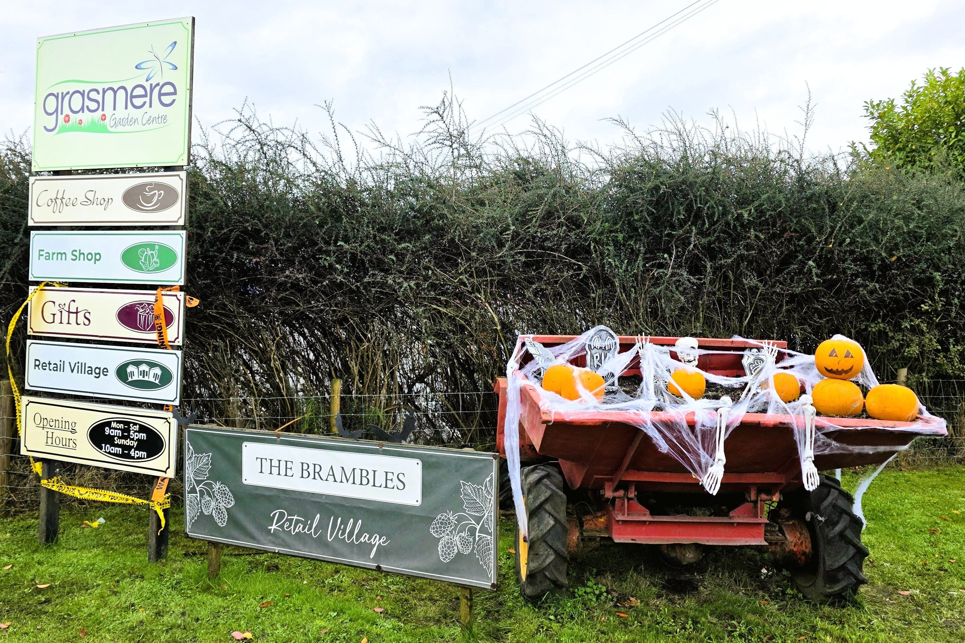 Tractor with pumpkins near a sign for The Brambles Retail Village.