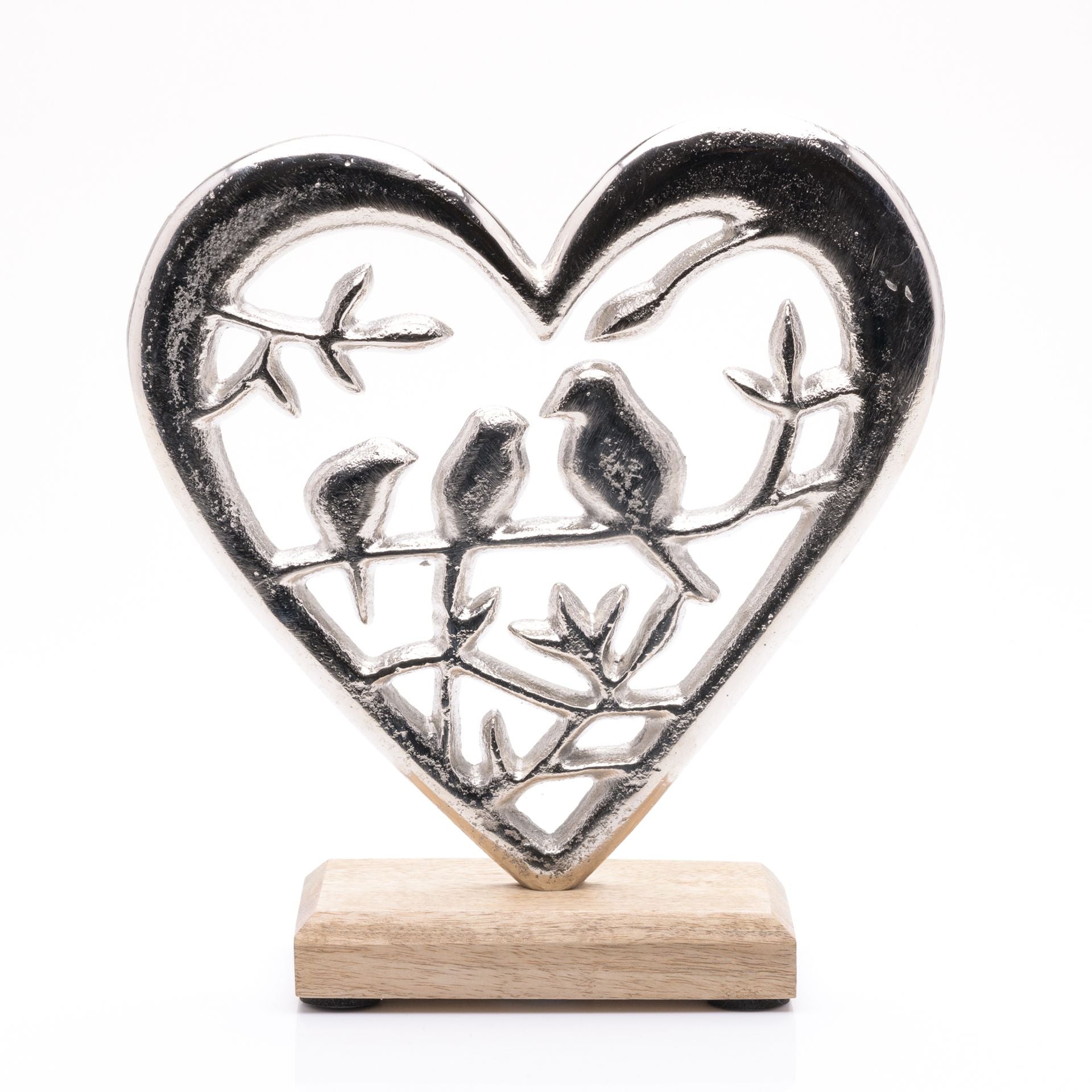 Decorative heart-shaped metal sculpture with birds on a wooden base against a white background