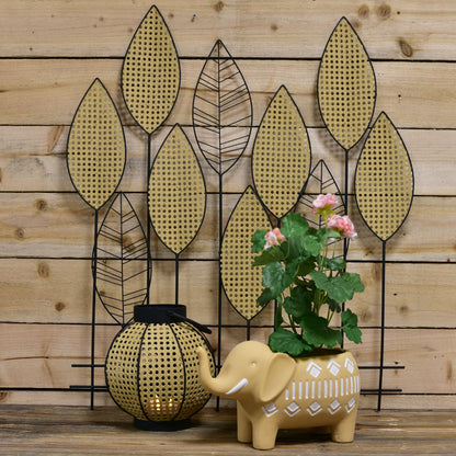 Elephant planter with flowers on a wooden background with metal leaves
