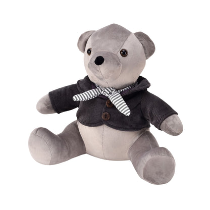 Gray teddy bear wearing a dark jacket with buttons and a striped scarf on a white background