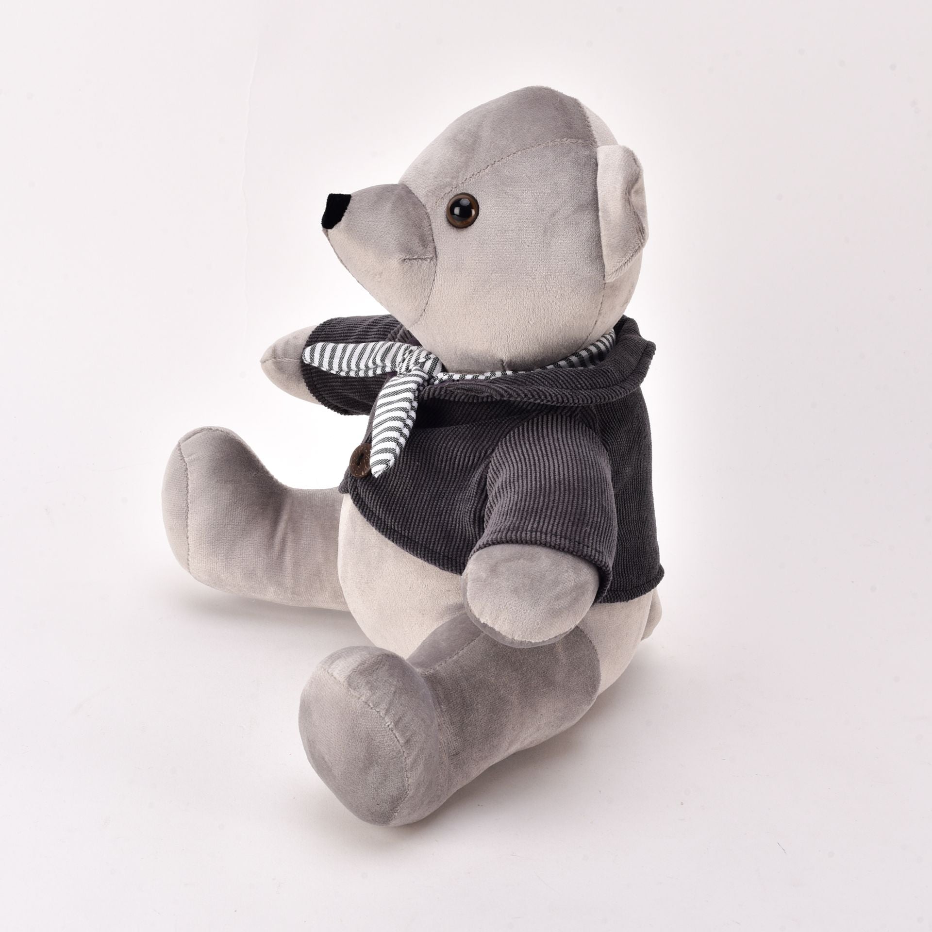 Gray teddy bear wearing a black sweater and striped scarf on a white background