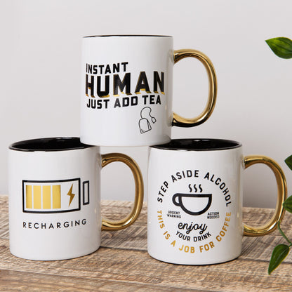 Three white mugs with humorous text designs on a wooden surface.
