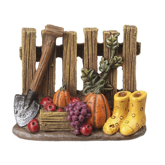 Decorative scene with a wooden fence, pumpkins, boots, and vegetables on a white background