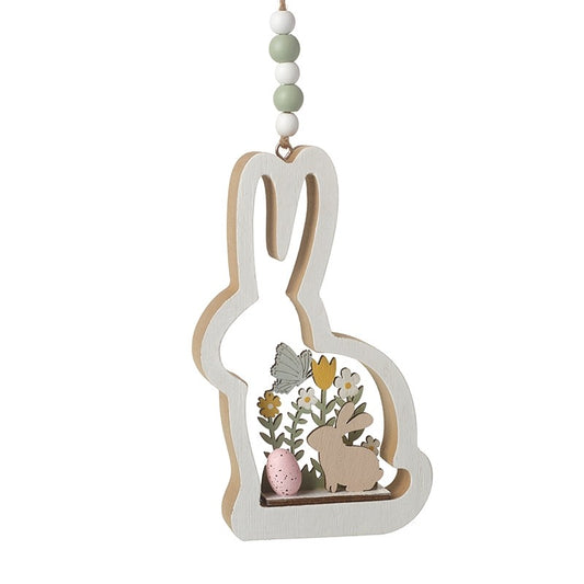 Decorative wooden bunny with cut-out design of flowers, butterflies, and eggs on a white background