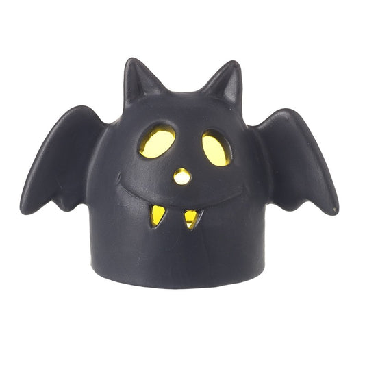 Black bat-shaped object with yellow glowing eyes and fangs on a white background